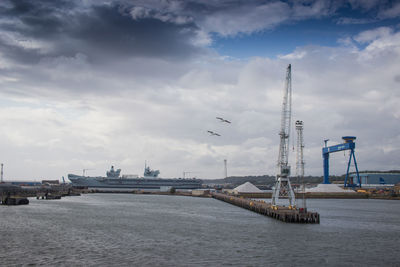 View of pier in sea against cloudy sky