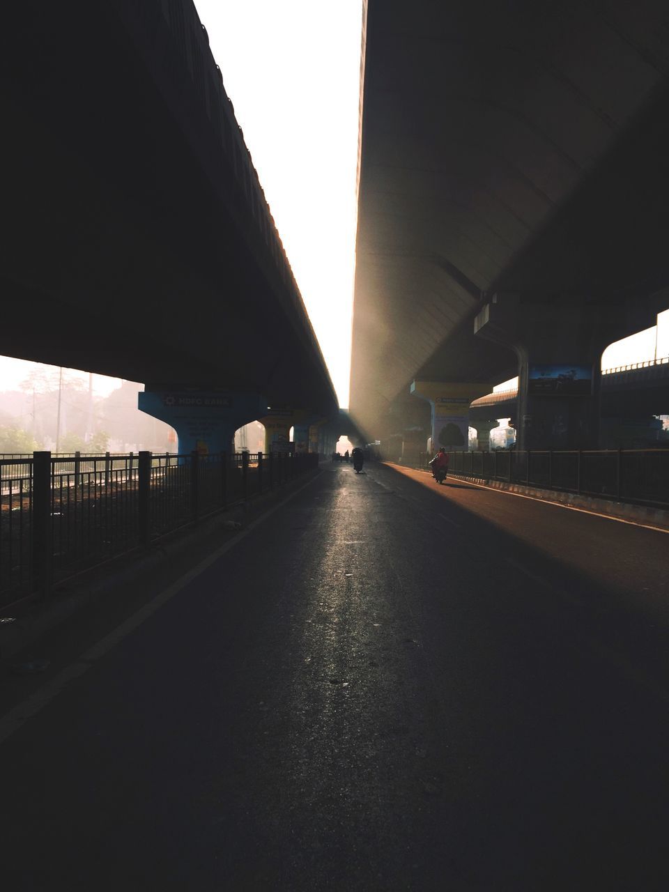 ROAD AMIDST ILLUMINATED CITY AGAINST SKY