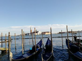 Gondolas moored in sea