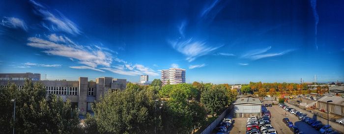 Panoramic view of city buildings against blue sky