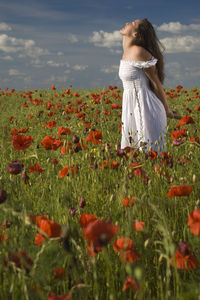 Woman standing on field against sky