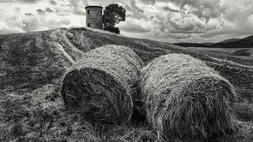Hay bales on field against sky