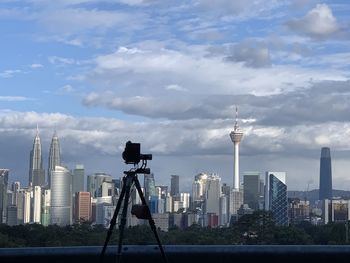 Modern buildings in city against cloudy sky