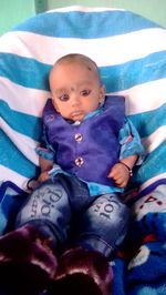 High angle portrait of cute baby lying on bed