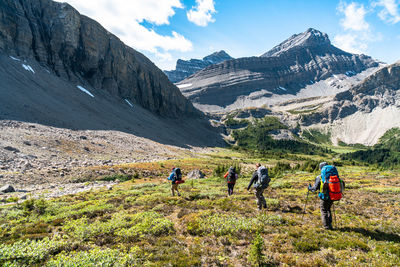 Group of trekkers descend into remote alpine valley near banff