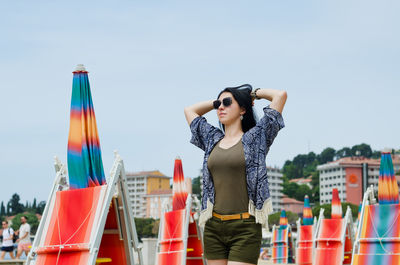 Full length of young woman exercising against sky