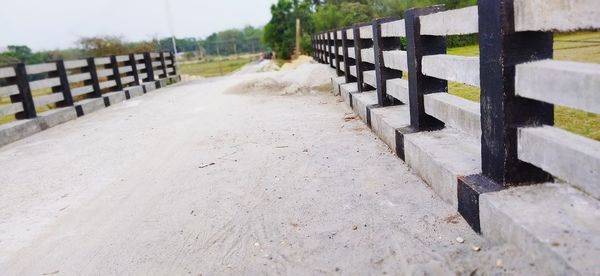 Close-up of footpath by fence