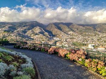 Scenic view of townscape by mountains against sky