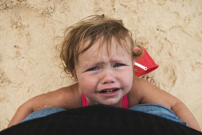 Portrait of cute boy playing on sand at beach