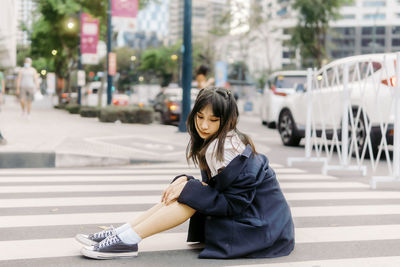 Young woman sitting on street