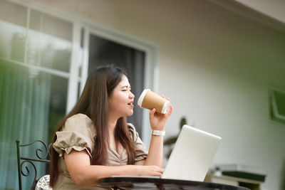 Young woman using mobile phone at home