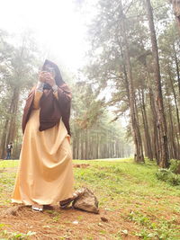 Rear view of woman photographing against clear sky