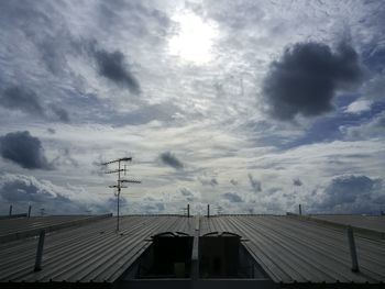 Low angle view of silhouette electricity pylon against storm clouds