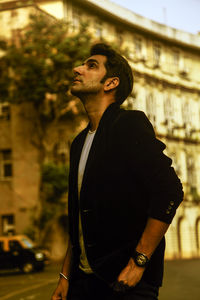 Side view of young man looking away in city