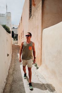 Man walking in narrow alley amidst buildings