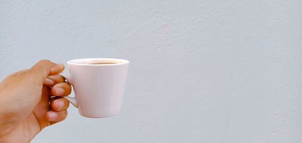 Midsection of person holding coffee cup