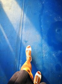 Low section of woman walking on blue floor