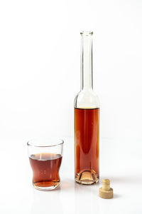 Close-up of glass of bottle against white background