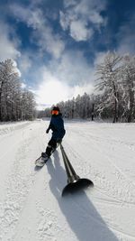 Full length of man doing selfie while snowboarding