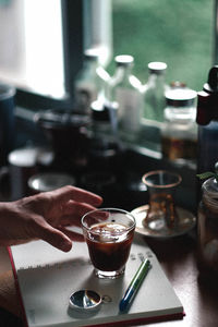 Midsection of person holding coffee on table in restaurant