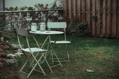 Empty chairs and table in lawn