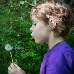 Close-up of girl holding purple flower