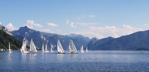 Sailboats sailing in sea against sky