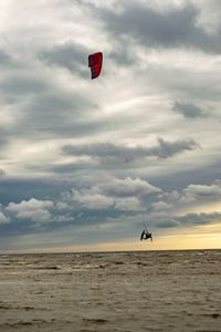 Kite flying over sea against sky