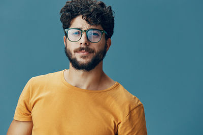 Portrait of young man against blue background