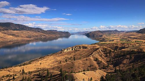 Scenic view of river amidst mountains against sky