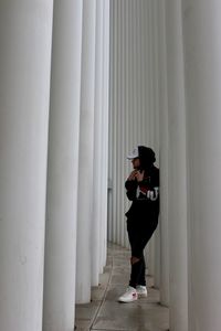 Full length of man standing amidst column