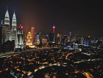 Illuminated buildings in city against sky at night