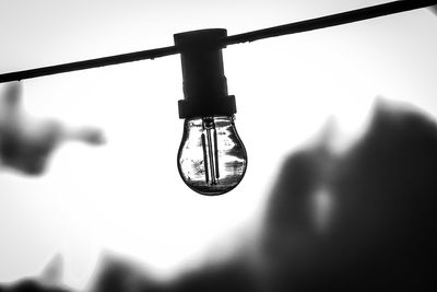 Close-up of light bulb against sky