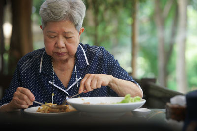 Young woman having food at home