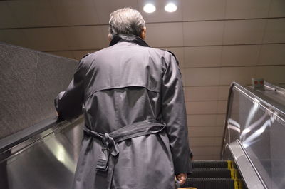 Low angle view of man standing on escalator