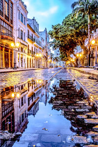 Canal amidst buildings against sky in city during winter