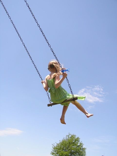 LOW ANGLE VIEW OF WOMAN HOLDING SWING