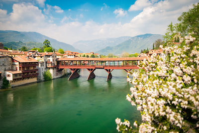 Arch bridge over river against sky