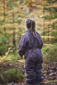 Rear view of woman walking on field
