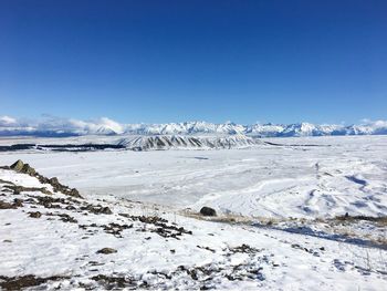 Scenic view of snowcapped mountains against blue sky