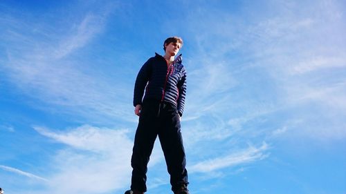 Low angle view of woman standing against sky