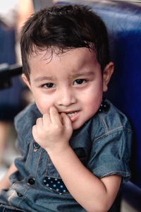 Close-up portrait of cute boy biting nails