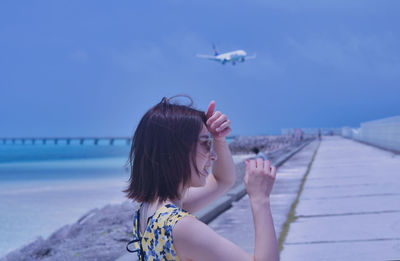 Portrait of woman against blue sea against sky