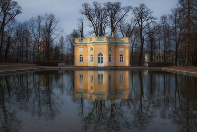 Reflection of building in lake against sky