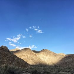 Scenic view of rocky mountains against blue sky