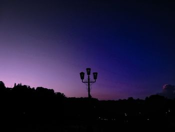 Silhouette trees against clear sky at sunset