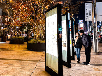 Full length of man standing at illuminated city