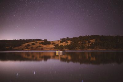 Scenic view of lake against clear sky at night