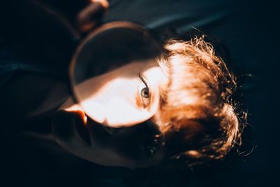 Portrait of woman looking through magnifying glass