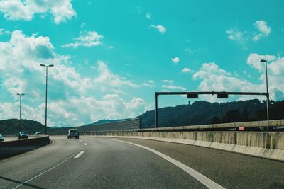 Empty road against cloudy sky